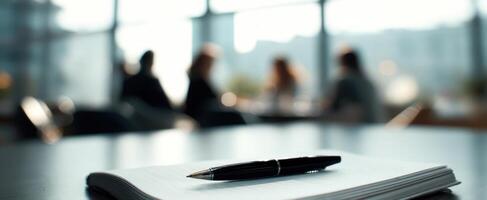 The pen resting on a notebook during a collaborative business meeting photo