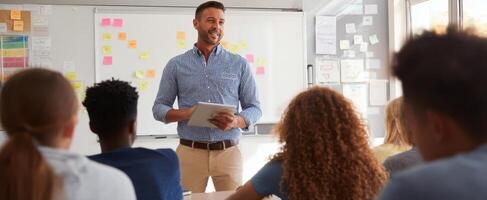 The teacher engaging students with technology in a dynamic classroom setting. photo