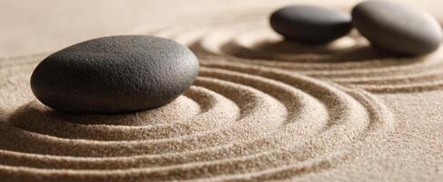 The serene black stones resting gently on smooth sand patterns photo
