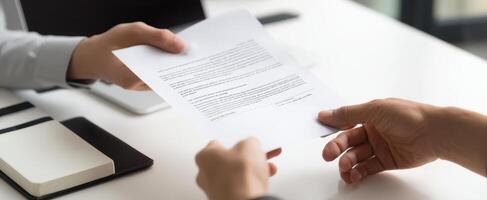 The hands exchanging a document in a professional business meeting setting. photo