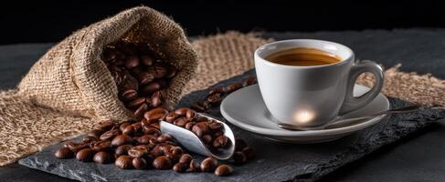 The elegant coffee cup with roasted beans and rustic burlap backdrop. photo