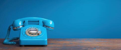 The Retro Blue Rotary Telephone on a Wooden Surface Against a Vibrant Background photo