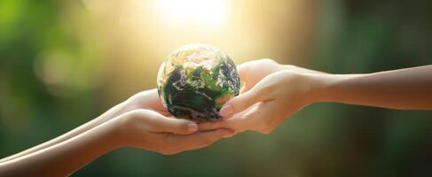 The hands exchanging the Earth symbolize unity and environmental responsibility. photo