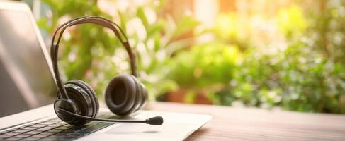 The stylish headset resting on a laptop in a serene outdoor workspace. photo