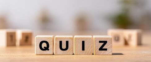 The wooden blocks spelling out quiz on a blurred background. photo
