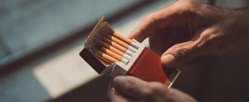 The Hands Holding an Open Cigarette Box in Soft Natural Light photo