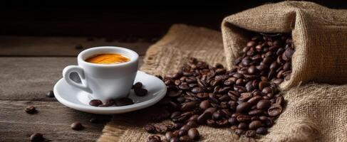 The steaming espresso cup beside freshly spilled coffee beans on rustic wood. photo