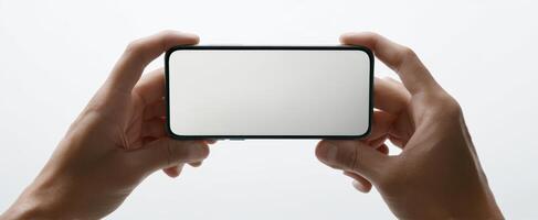 The hands holding a smartphone with a blank screen on a minimalist background. photo