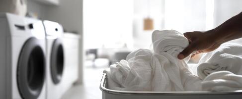 The laundry basket filled with freshly washed white clothes in a modern home setting. photo
