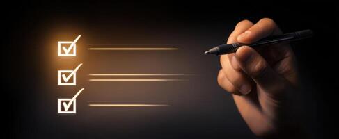The hand completing a checklist with a pen in a dark environment. photo