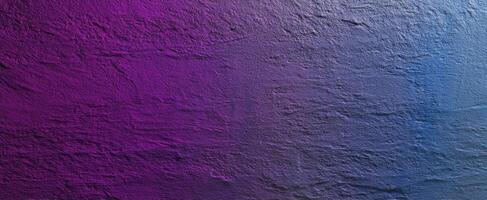 The gradient texture of a purple and blue wall surface. photo