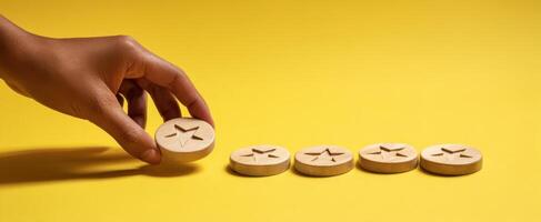 The hand placing a wooden star token on a vibrant yellow background. photo
