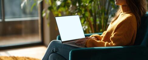 The woman sitting comfortably with a laptop in a sunlit indoor setting. photo