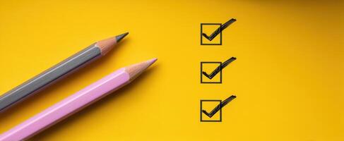 The colorful pencils and checklist on a vibrant yellow background. photo