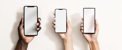The collection of smartphones held by diverse hands against a light background photo