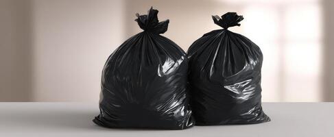 The black garbage bags sitting on a clean surface against a blurred background. photo
