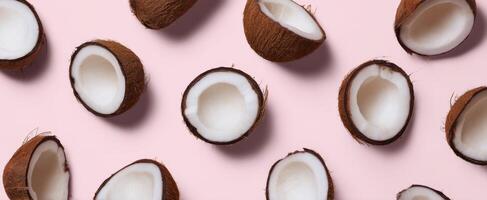 The coconut halves arranged beautifully on a pastel pink background. photo