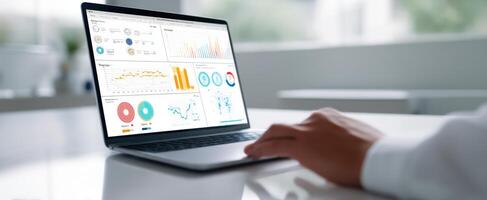 The laptop displaying analytical graphs and data in a modern workspace. photo
