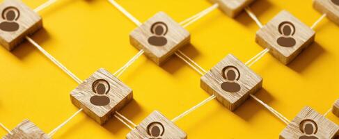 The Networking Connection with Wooden Figures on a Vibrant Yellow Background photo