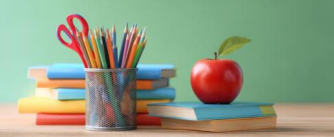 The vibrant classroom setup with colorful pencils, books, and a fresh apple. photo