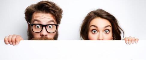 The surprised couple playfully holding a blank sign in a studio setting. photo