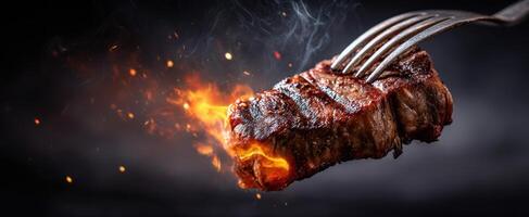 The sizzling steak perfectly grilled with flames and a fork. photo
