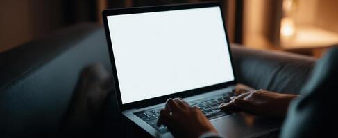 The Laptop on a Couch During an Evening Work Session. photo