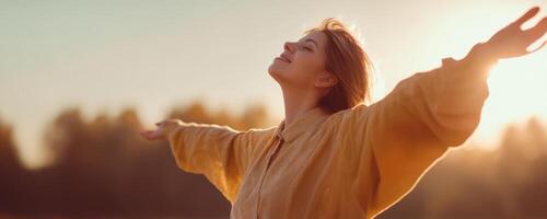 The woman embracing freedom with open arms in a sunset field. photo
