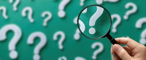 The Magnifying Glass Highlighting Questions on a Green Background photo