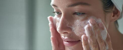 The woman cleansing her face with gentle bubbles in a serene setting. photo