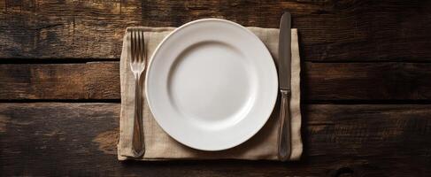 The elegant dining plate with cutlery on a rustic wooden table setting. photo