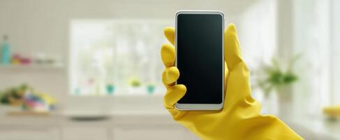 The smartphone held by a gloved hand in a clean kitchen environment. photo
