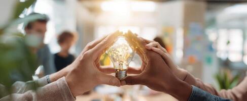 The hands around a glowing lightbulb symbolize innovative teamwork and bright ideas. photo