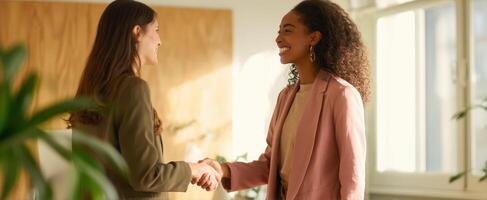 The successful businesswomen shaking hands in a bright office setting. photo
