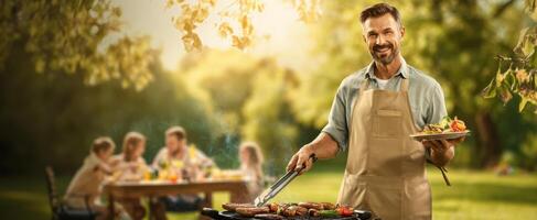 The joyful man grilling sausages at a lively outdoor summer gathering. photo