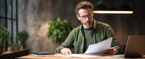 The focused man reviewing important documents in a modern office workspace. photo