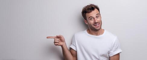 The smiling man pointing happily against a plain background. photo