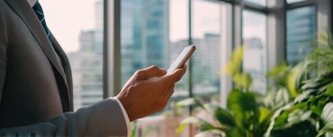The professional man interacts with a smartphone in a bright urban office. photo