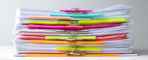 The colorful stack of organized papers with binder clips. photo