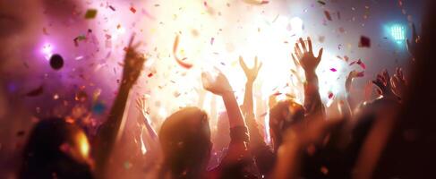 The vibrant celebration with hands raised amidst confetti and colorful lights photo