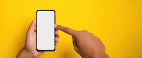 The smartphone held by a hand against a vibrant yellow background. photo