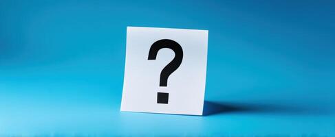 The question mark on a sticky note against a serene blue backdrop. photo