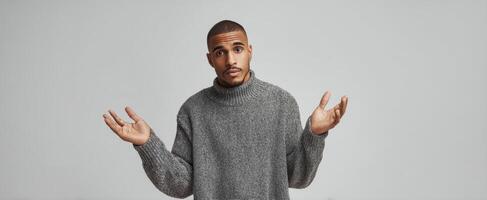 The man in a cozy gray sweater expressing confusion and uncertainty. photo