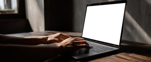 The laptop with hands typing in an ambient workspace setting. photo