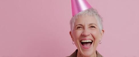 The joyful woman celebrating her birthday with a bright pink party hat. photo