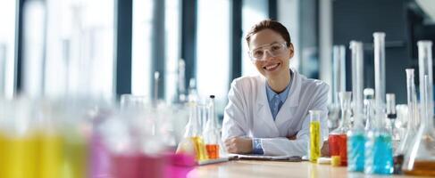 The smiling scientist in a colorful laboratory surrounded by glassware and experiments. photo