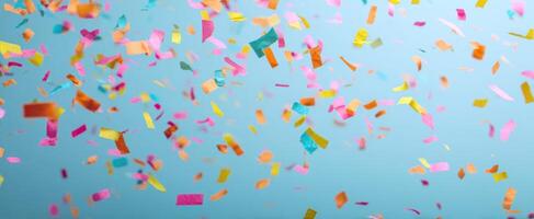 The colorful confetti celebrating joyfully against a blue background. photo