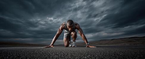 The athlete preparing to sprint on a dramatic overcast racetrack. photo
