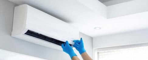 The technician performing maintenance on a modern air conditioning unit in a home. photo