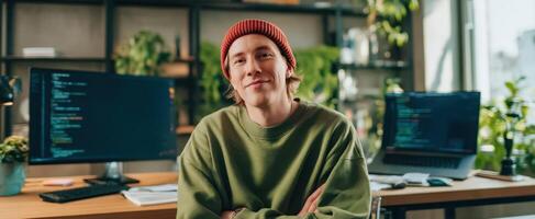 The young programmer in a modern workspace with lush greenery. photo